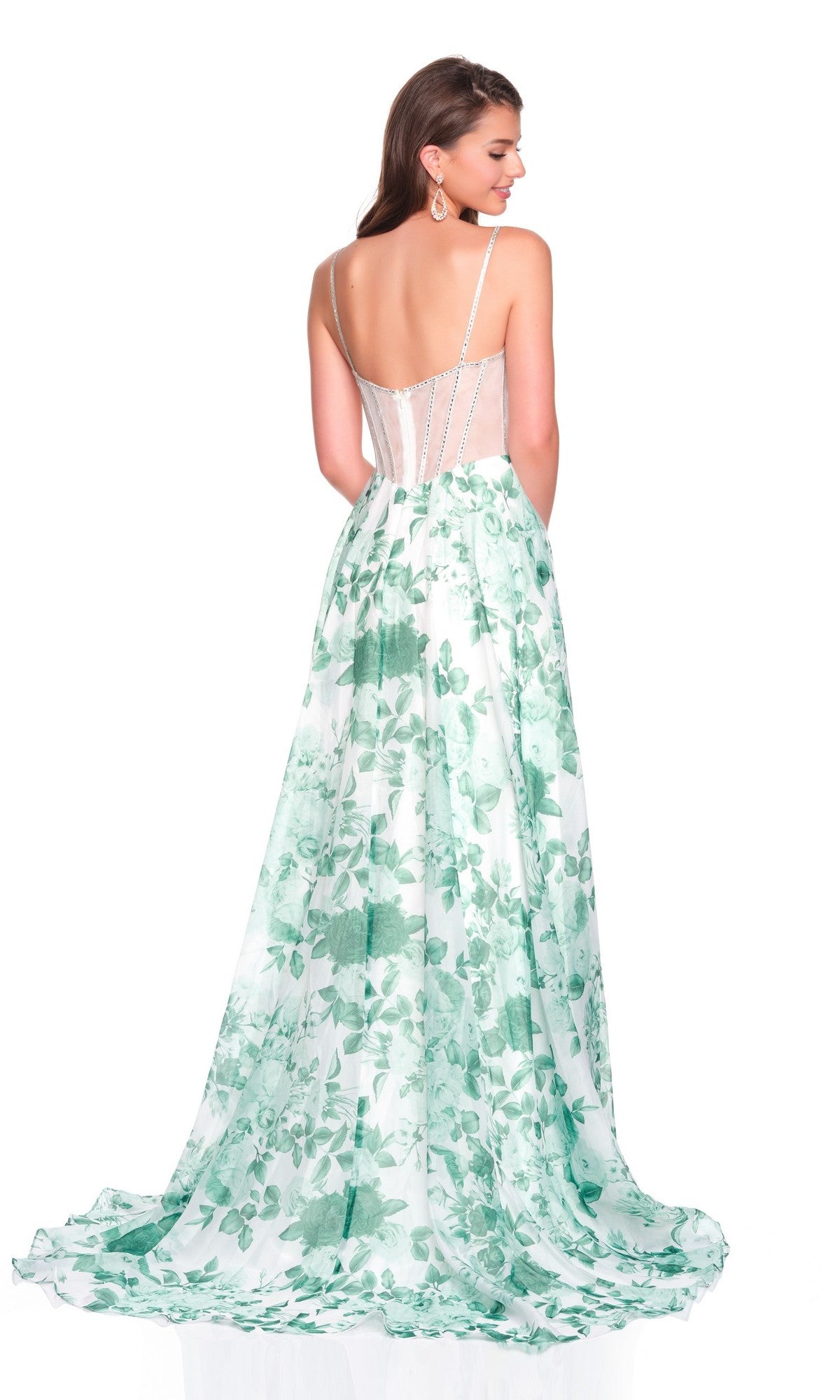 A woman stands facing away from the camera, wearing the Long Prom Dress: Dave and Johnny 12686—a green and white floral gown with thin straps, a sheer back panel, and a corset bodice.
